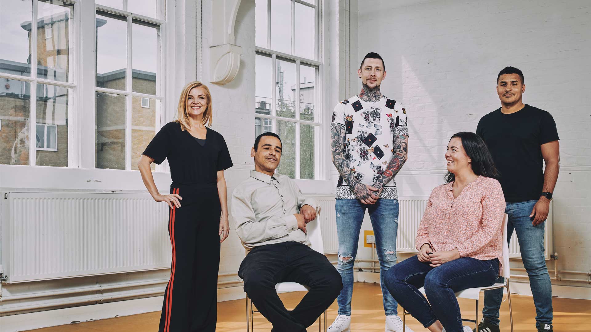a group of people sitting and standing, smiling