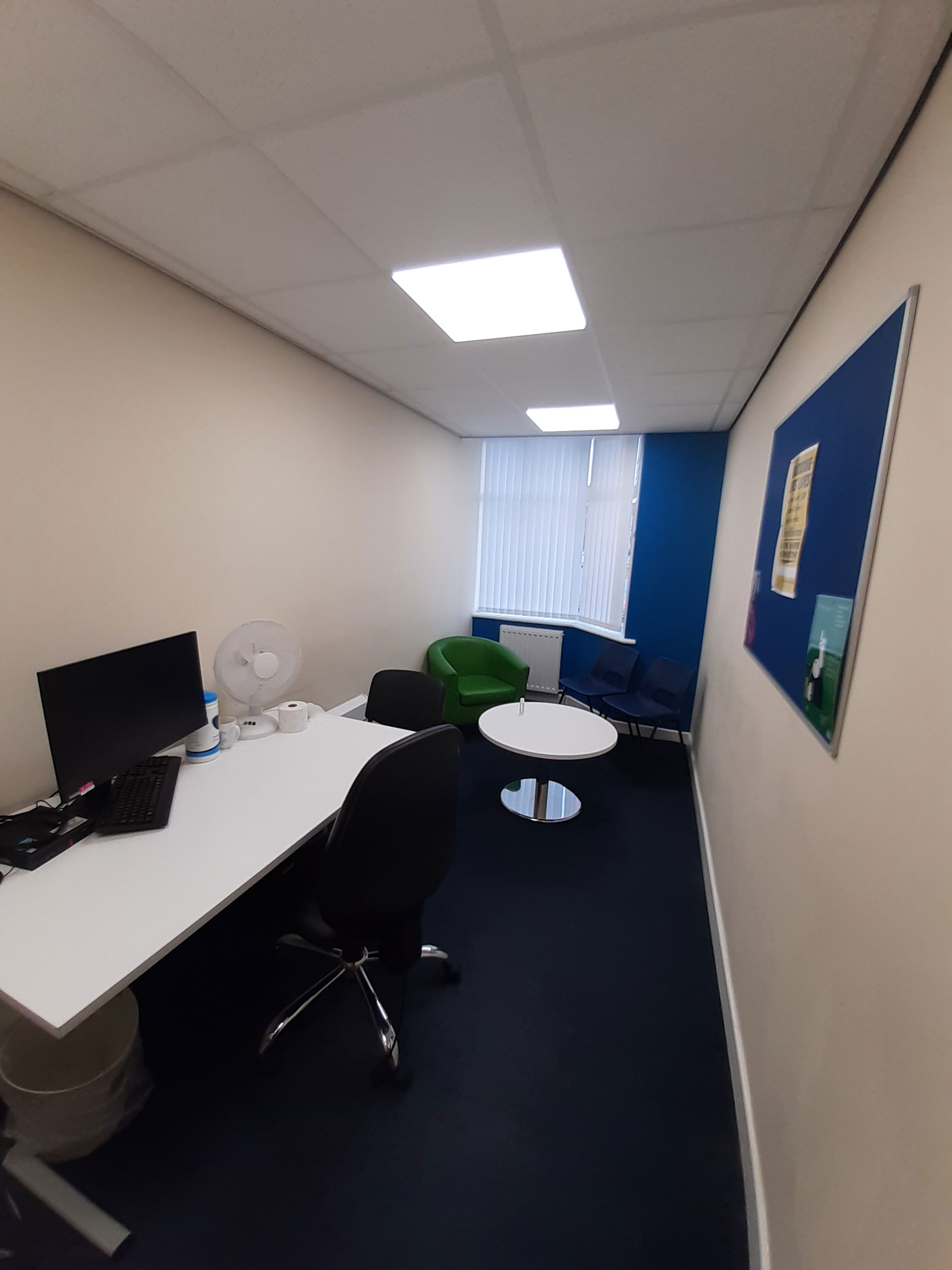 Macclesfield 121 and counselling room - a room with white walls, a computer on a desk, and two chairs around a small circular table