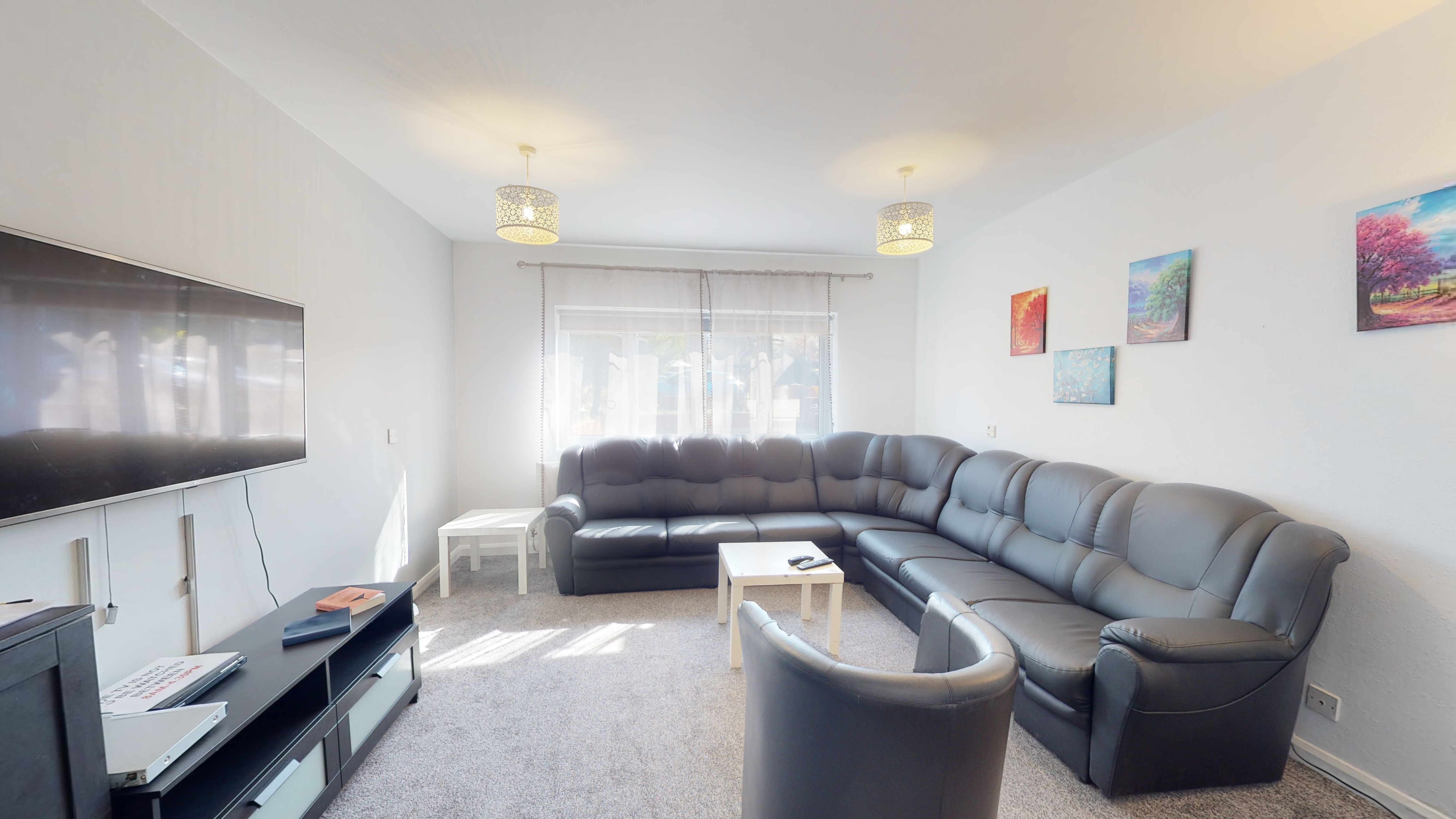 Liberty House Group Room - a bright room with dark sofas white walls.