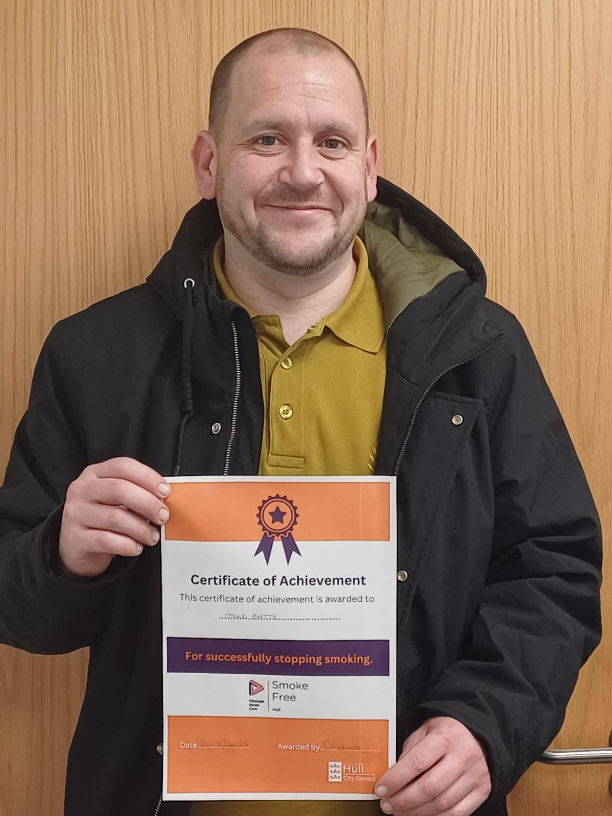 A man holding up a certificate