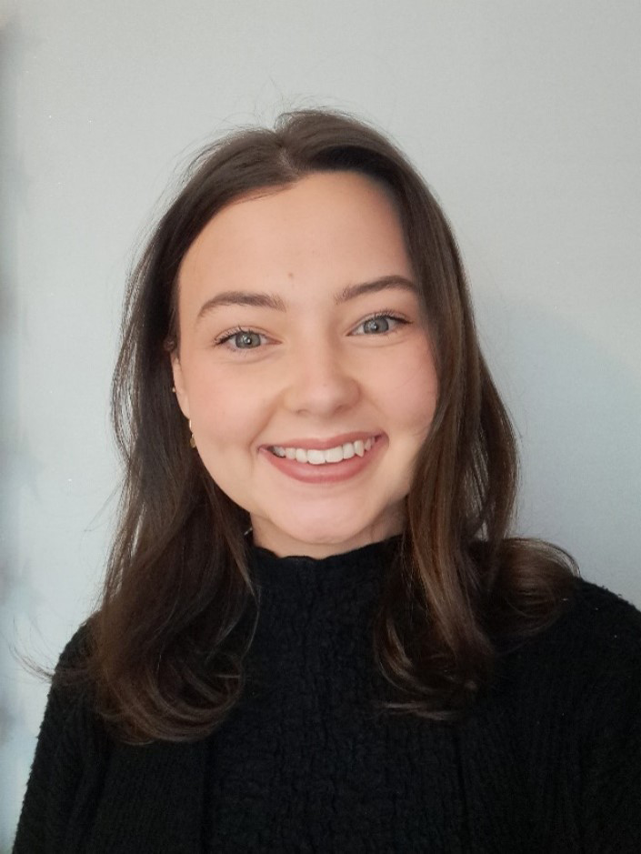 A dark haired woman smiling at the camera