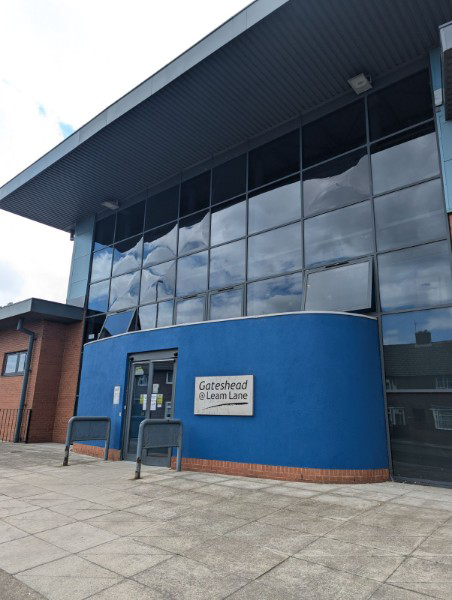 The outside of a blue building with big windows