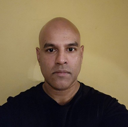 Head and shoulders of a bald man facing the camera