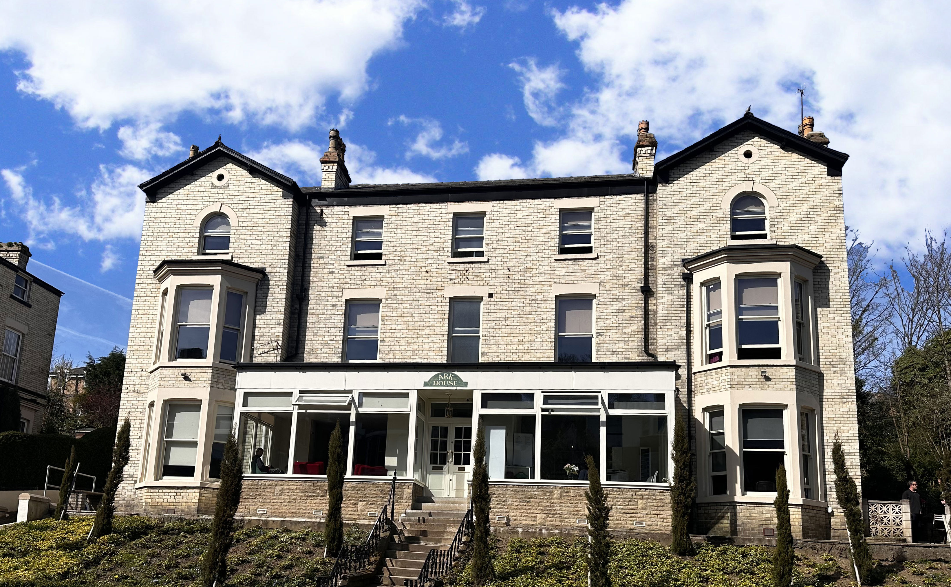 The outside of a building with 3 stories, and a conservatory