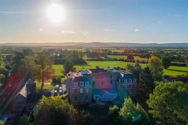 A ariel shot of a manor house set in the rolling countryside