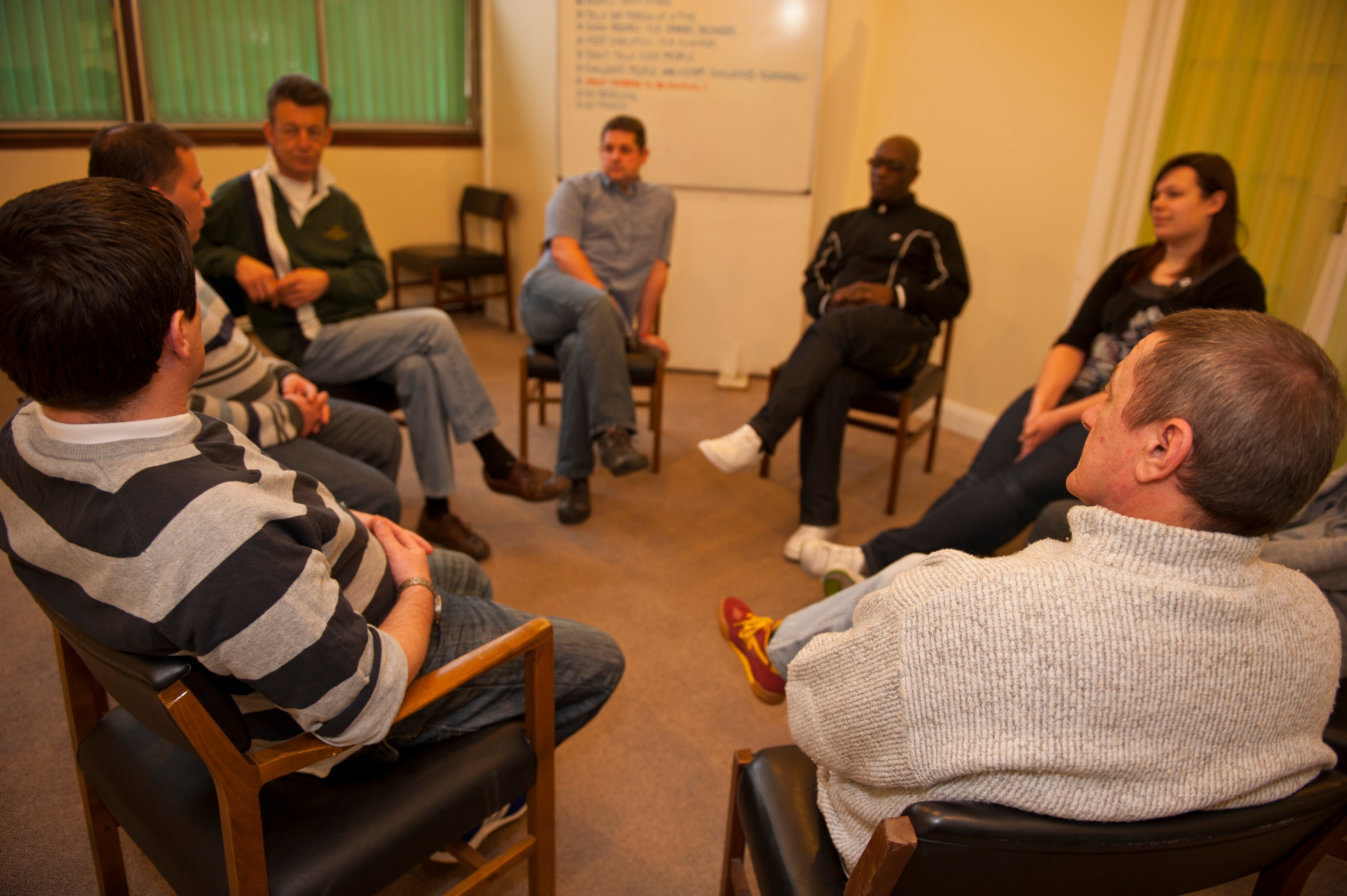 A group of people sat around in a circle having a discussion