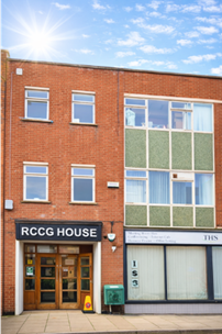 A red brick building with a sign over the door reading 'RCCG House'