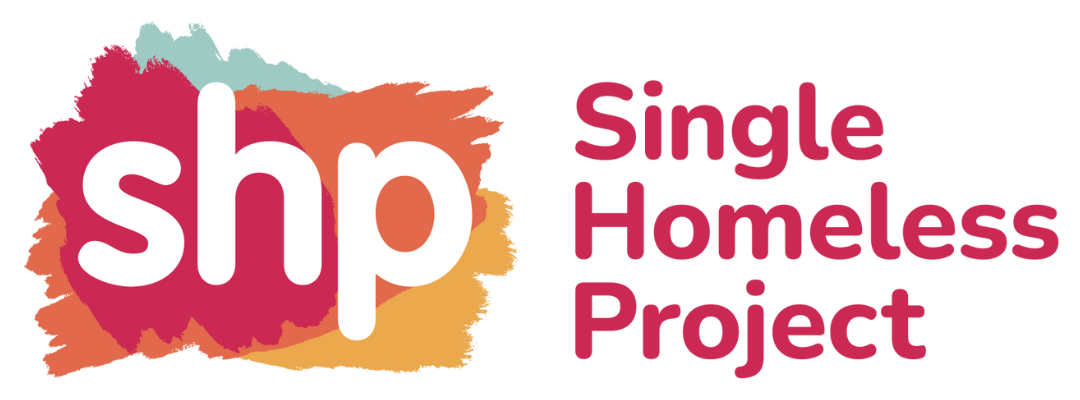 SHP is on top of paint strokes in red, orange, yellow, and green with Single Homeless Project written next to it in red