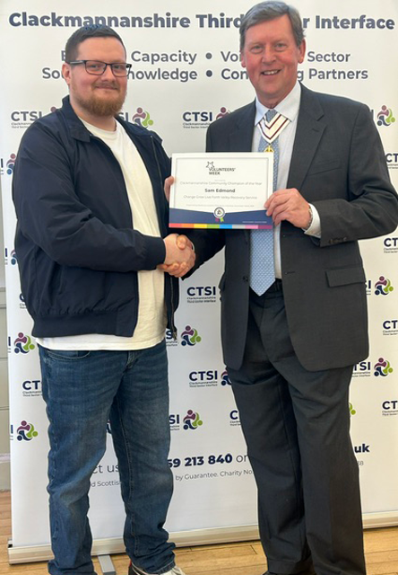 A man presenting another man with a certificate