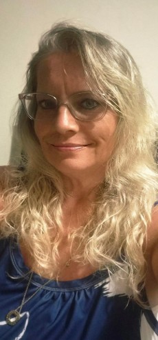 Annette has long blonde hair and wears glasses