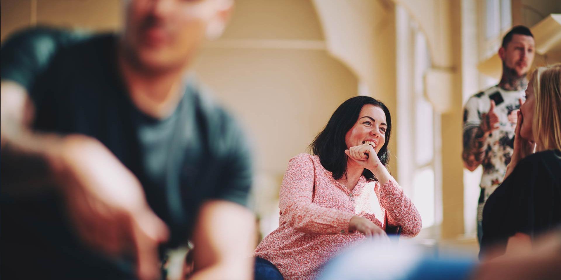 lady sitting on a chair talking to someone and laughing