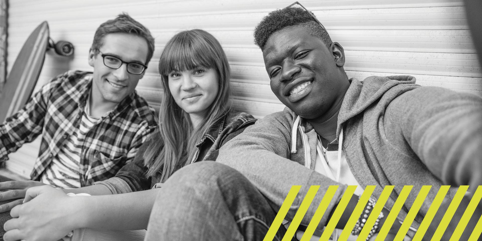 Three young people taking a group selfie
