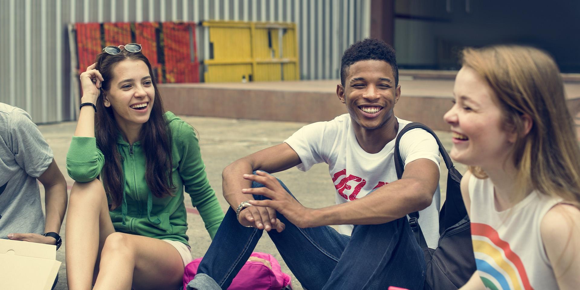 Three young people laughing and talking