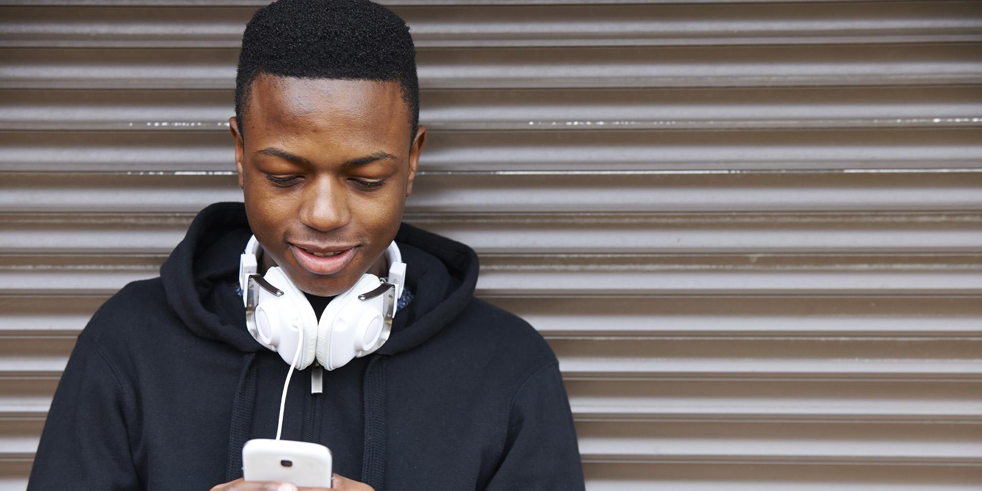 Young person looking down at phone