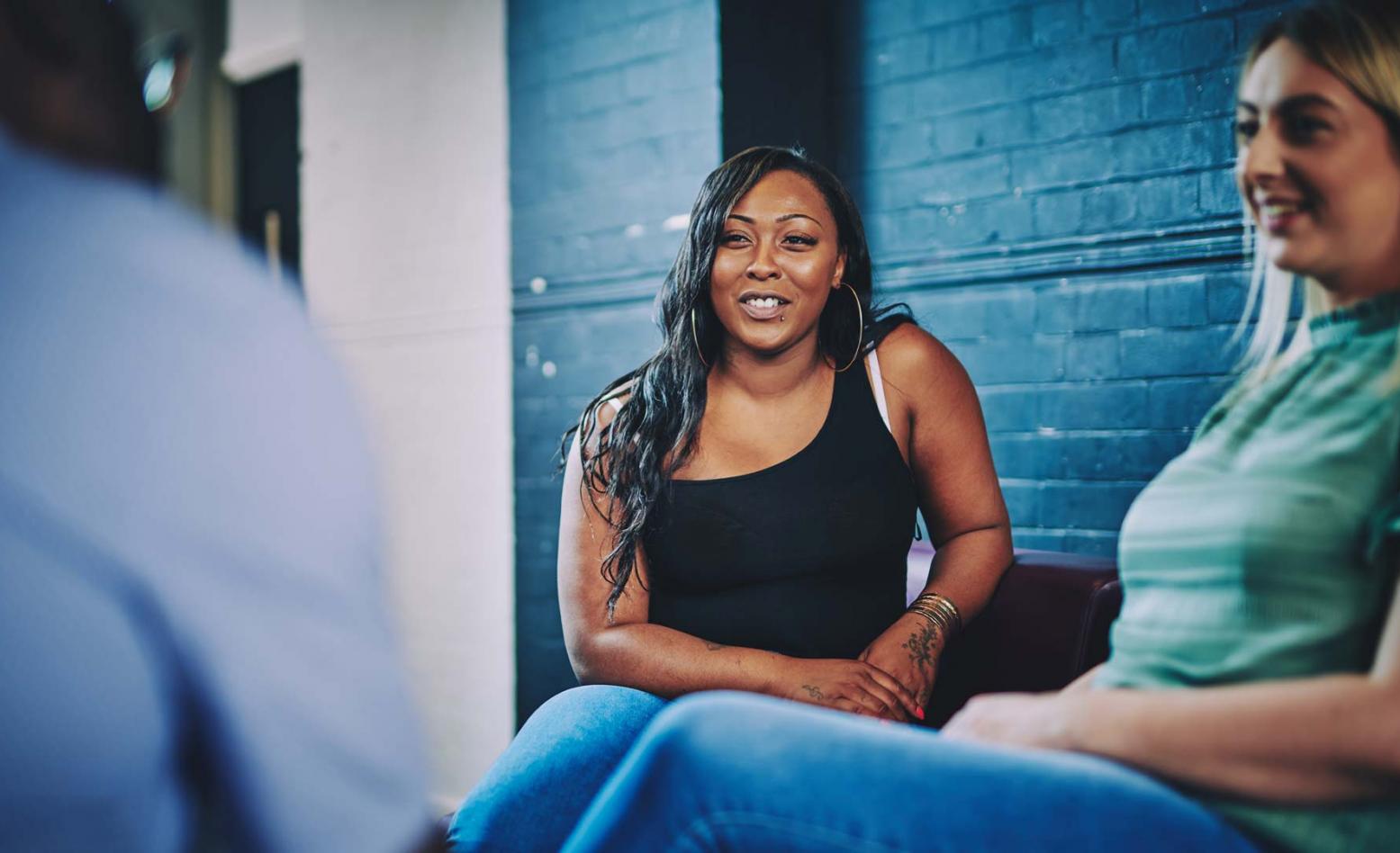 two women sat smiling and talking