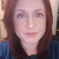 A woman with red hair smiling at the camera