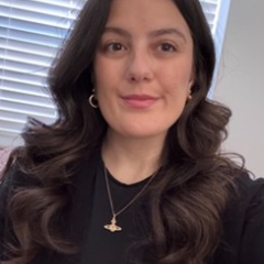 Christina has long dark hair and is smiling at the camera
