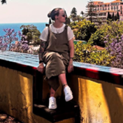 A young woman sat on a wall overlooking the countryside