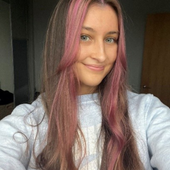 Gabby has long brown hair with a pink fringe