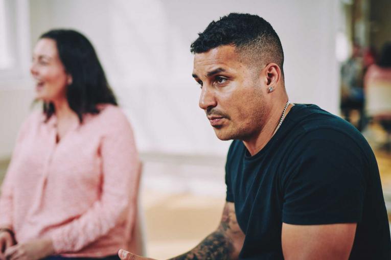 A man and a woman are sitting having a conversation