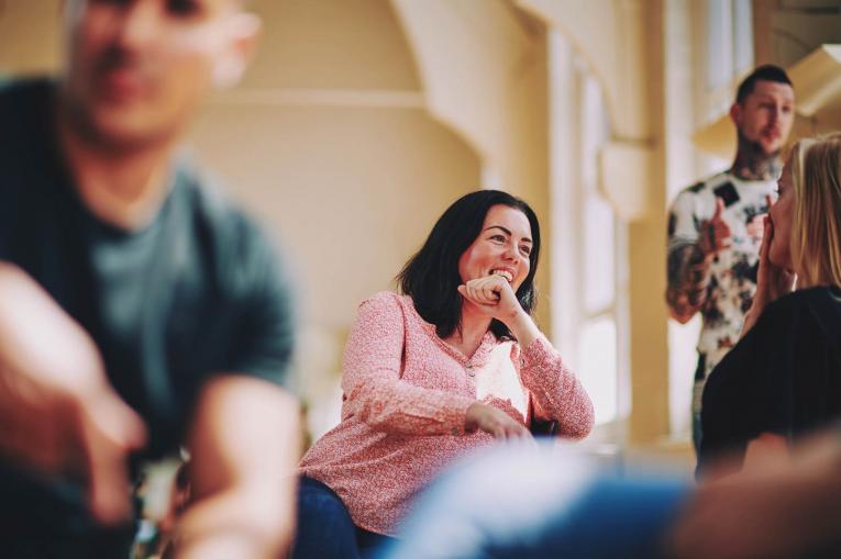 lady sitting on a chair talking to someone and laughing