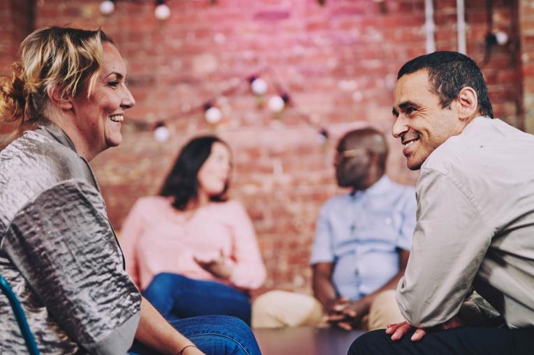 a group of people are sitting having a conversation