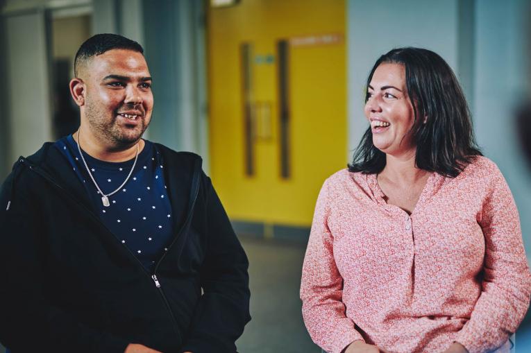 a man and a woman talking and smiling