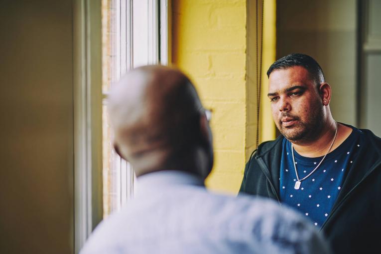 two men talking in a corridor