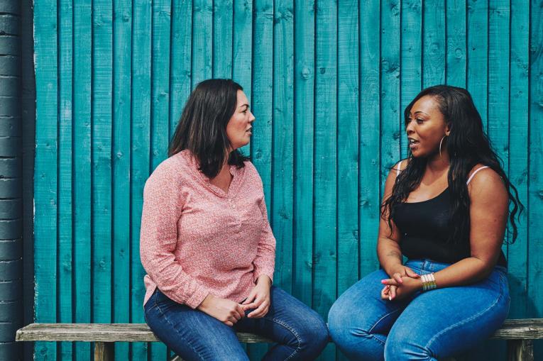 Two women are sitting outside having a conversation
