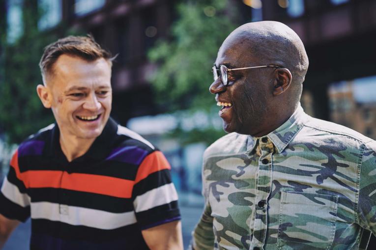 two men talking and smiling