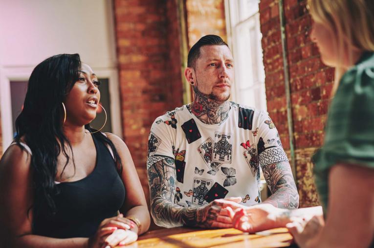 Two women and a man are sitting having a conversation