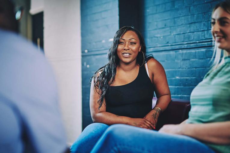 two women sat smiling and talking