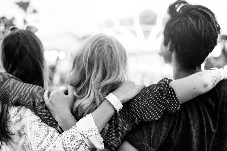 Three young people with their arms around each other