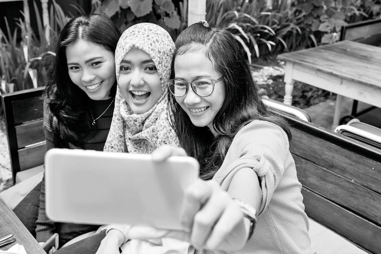 Three young people taking a group selfie