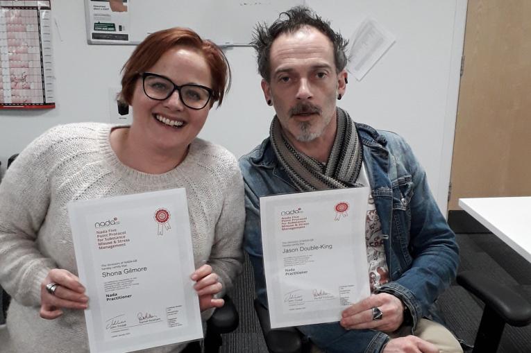 Two people in the Norfolk service with certificates for acupuncture