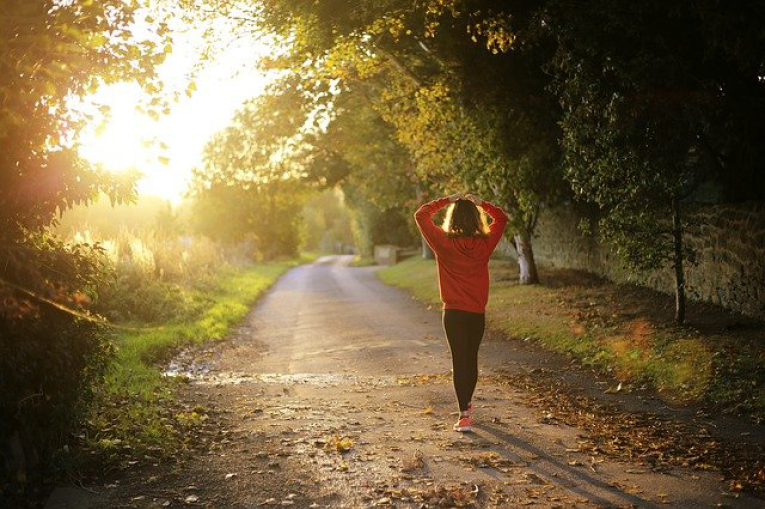 A woman walking in the woods at golden hour