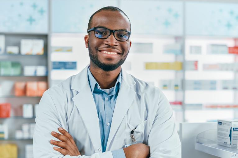 A male pharmacist smiling at the camera