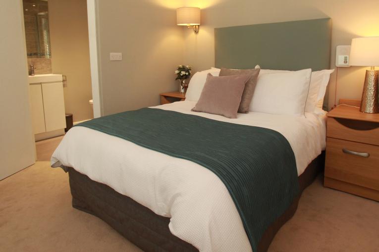 A double bed with a bedside table next to it.