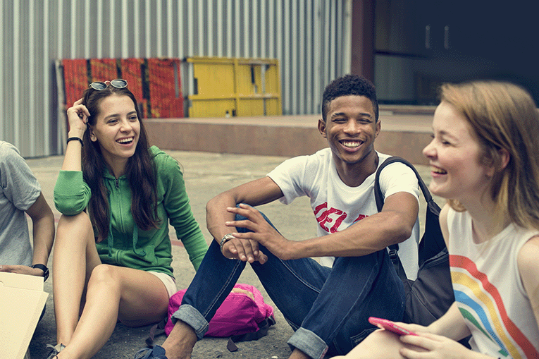 Three young people outside talking and laughing