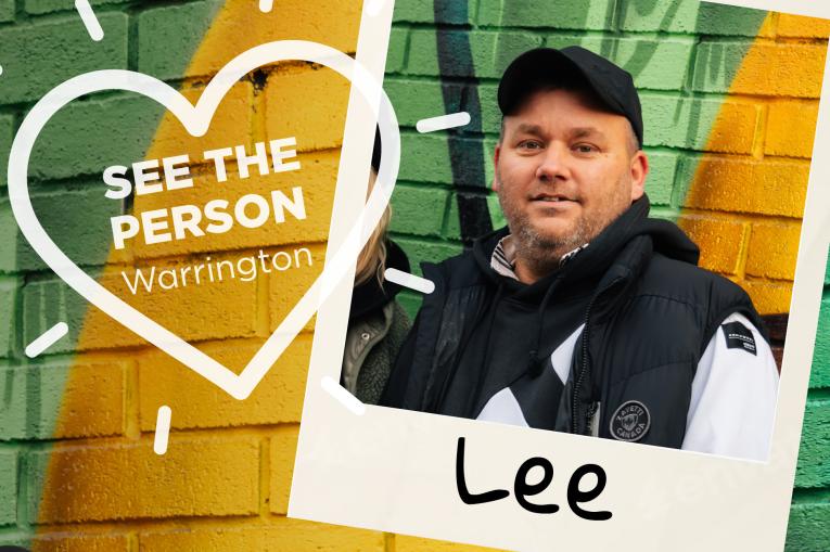A colourful wall background with a heart stamp on the left with the words See The Person Warrington inside the heart. On the right is a polaroid photo with a man wearing a black baseball cap and black jumper. The name Lee is at the bottom of the polaroid.