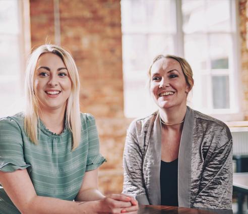 Three people are sitting together smiling