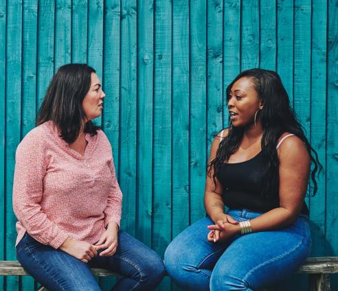 Two women are sitting outside having a conversation