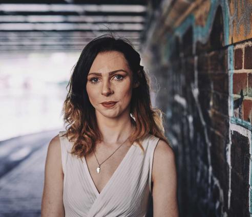 woman standing under a bridge
