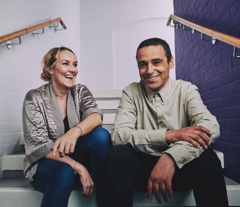 a woman and a man sitting on the stairs laughing