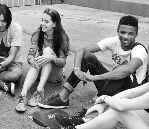 group of teenagers sitting around eating and talking