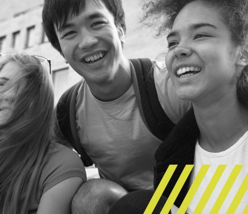 Three young people smiling and hugging