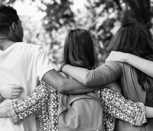 group of young people with arms round each other outside