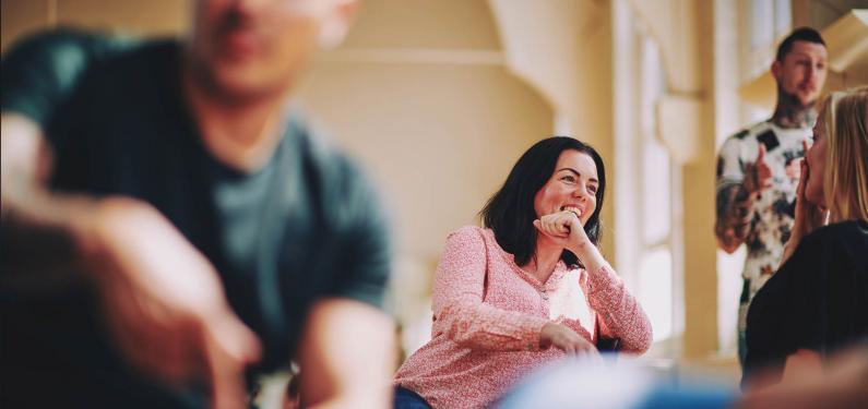 lady sitting on a chair talking to someone and laughing