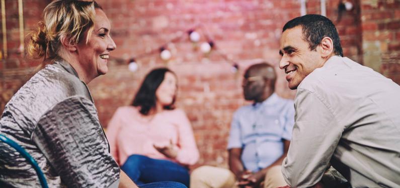 a group of people are sitting having a conversation