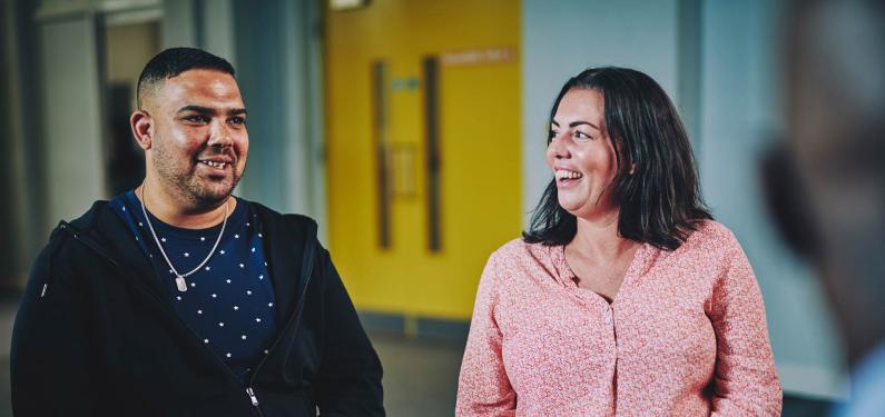 a man and a woman talking and smiling